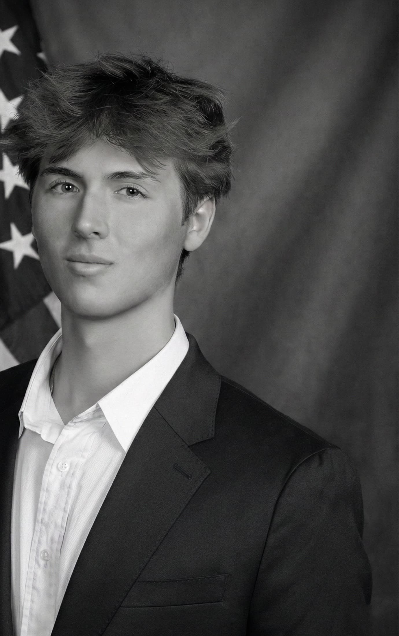 Black-and-white studio portrait of Caden Tacoronte in a dark suit and white shirt.